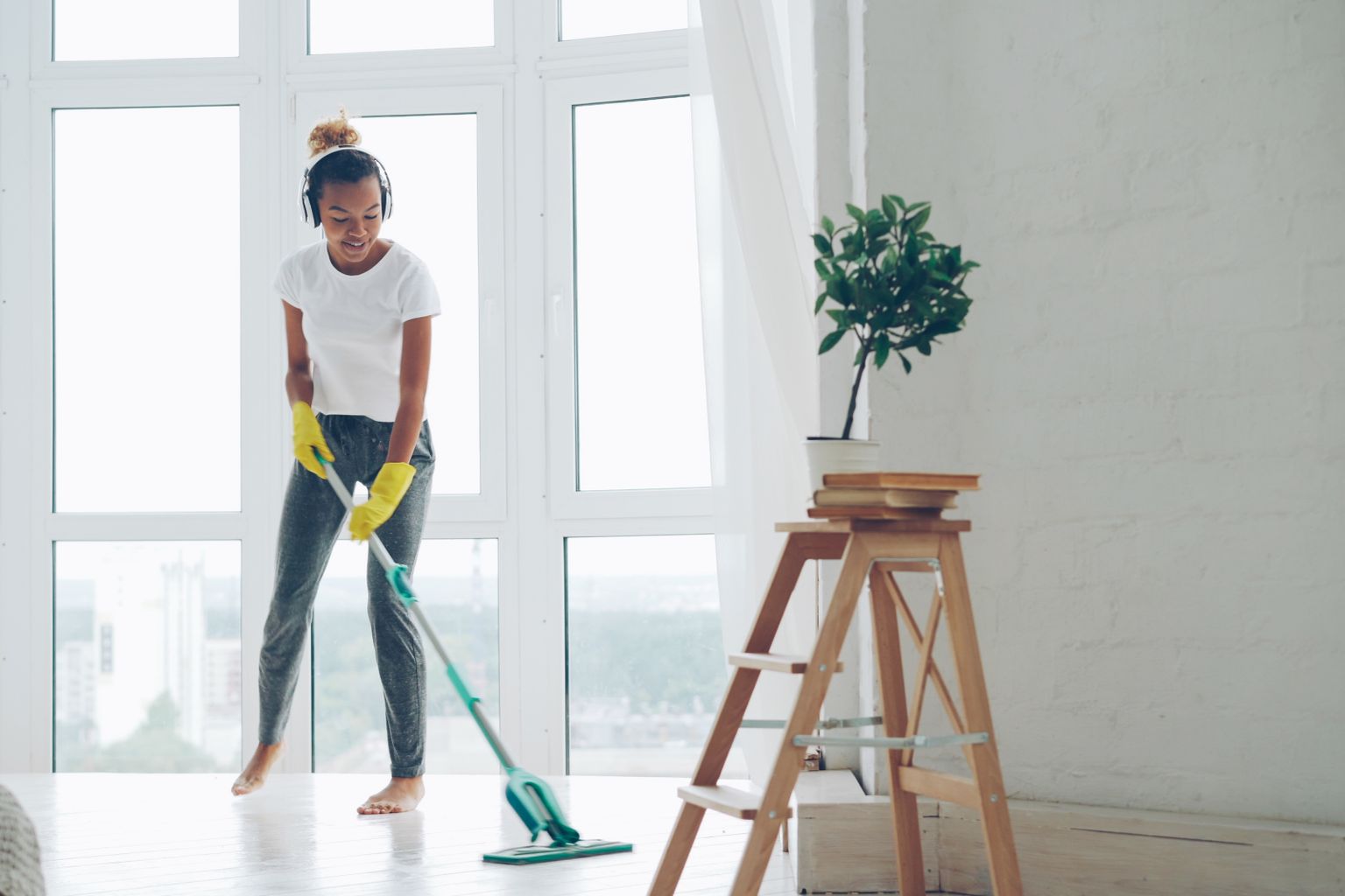 Cleaner mopping the floor of a bright living room